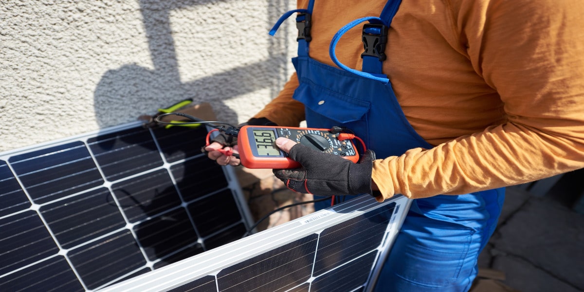 DIY Solar Power Systems: Are They Worth It? Expert Electric technician tests DIY solar power system panel output with multimeter.