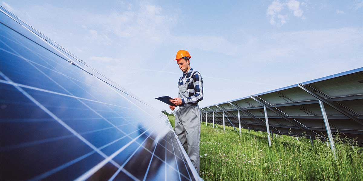 An engineer inspecting solar panel installations in a solar farm, symbolizing renewable energy innovations and the future of solar power.