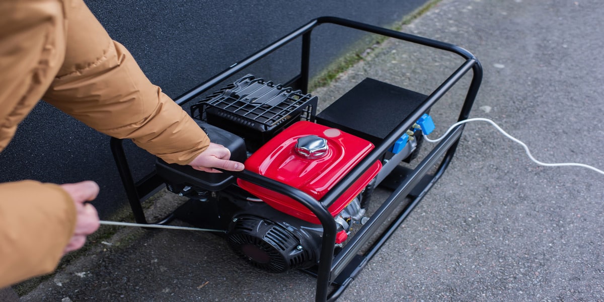 Generator Maintenance 101: Tips to Keep Your Power Running—Expert Electric shows manual startup of a red generator, key to regular generator maintenance.