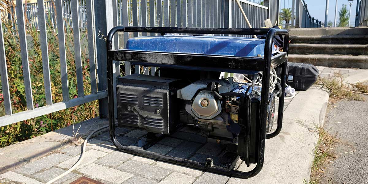 A blue portable gas generator placed outdoors on a paved surface, featuring a rugged design suitable for emergency power or construction use.