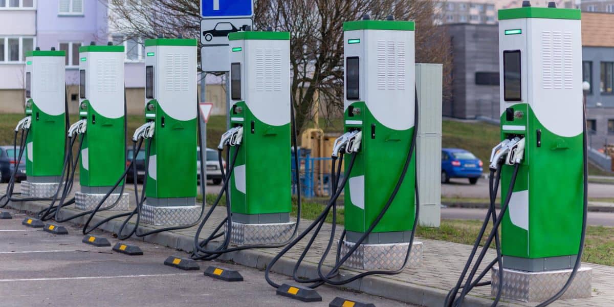 Understanding EV Charging Stations: Types, Locations, and Costs shown with public fast EV charging stations in a residential lot by Expert Electric.