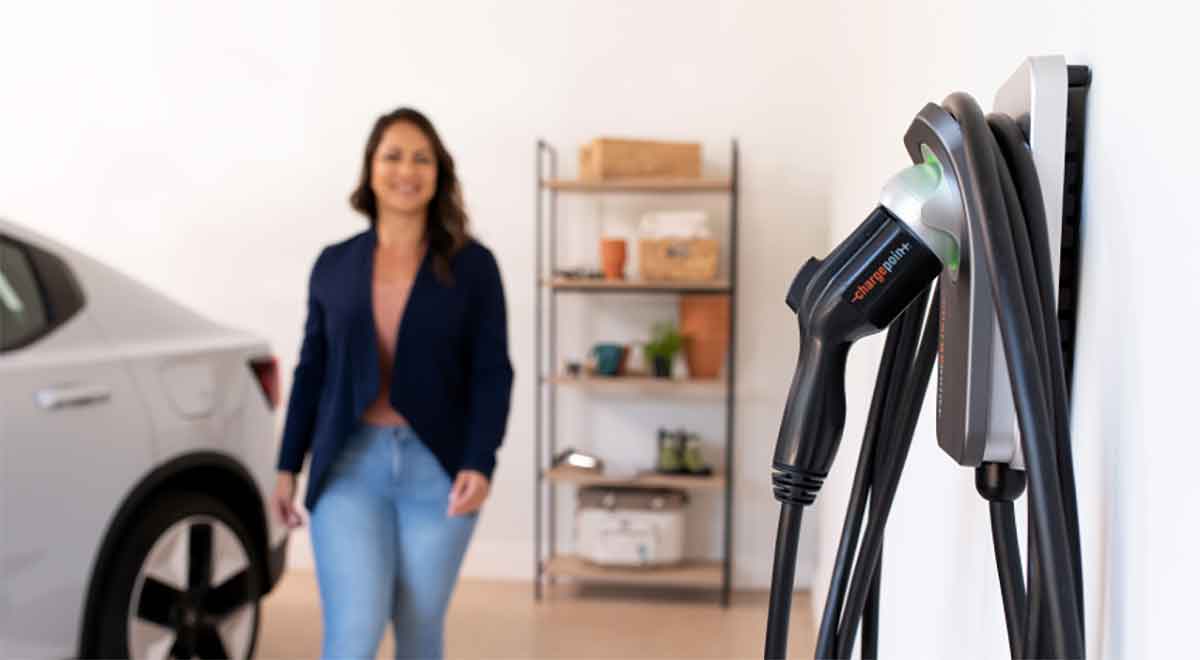 Woman walking towards a Chargepoint EV Charger in the foreground