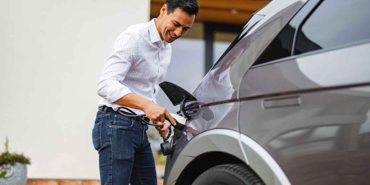 Man plugs in his electric vehicle with an EV Charger