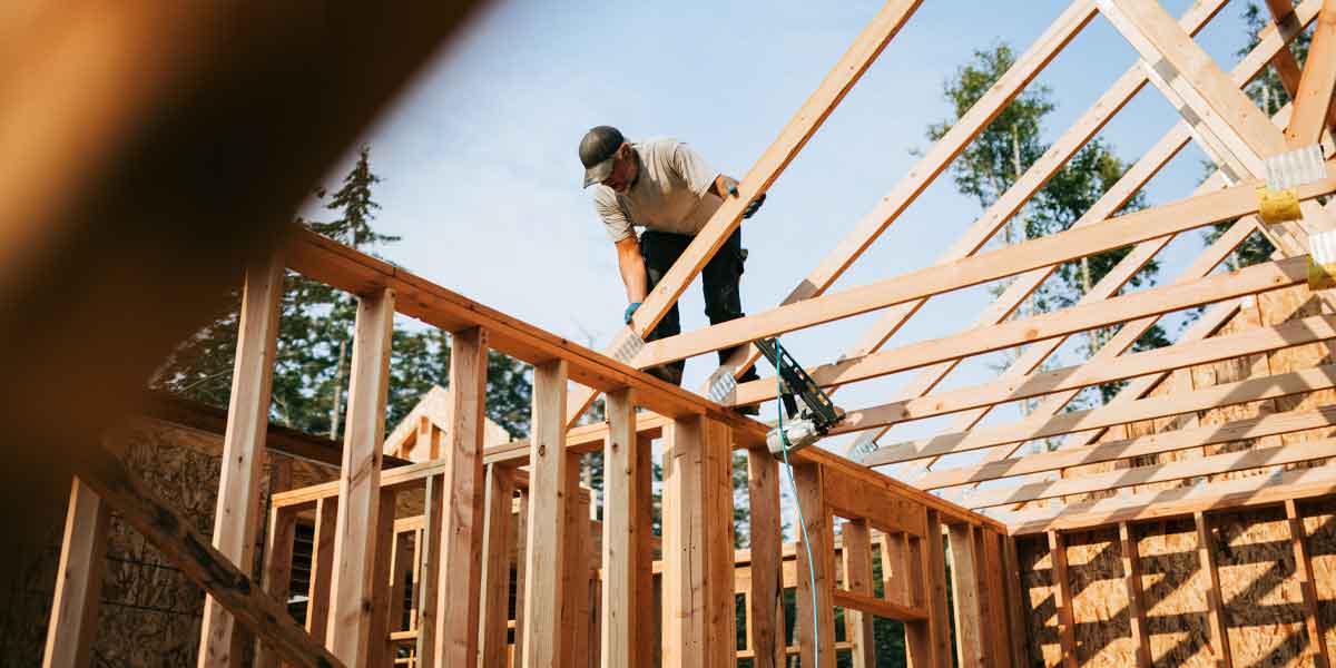 Man putting in trusses for a home on a construction site.
